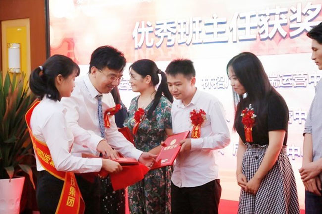 爱华教育董事长为教师颁发奖状